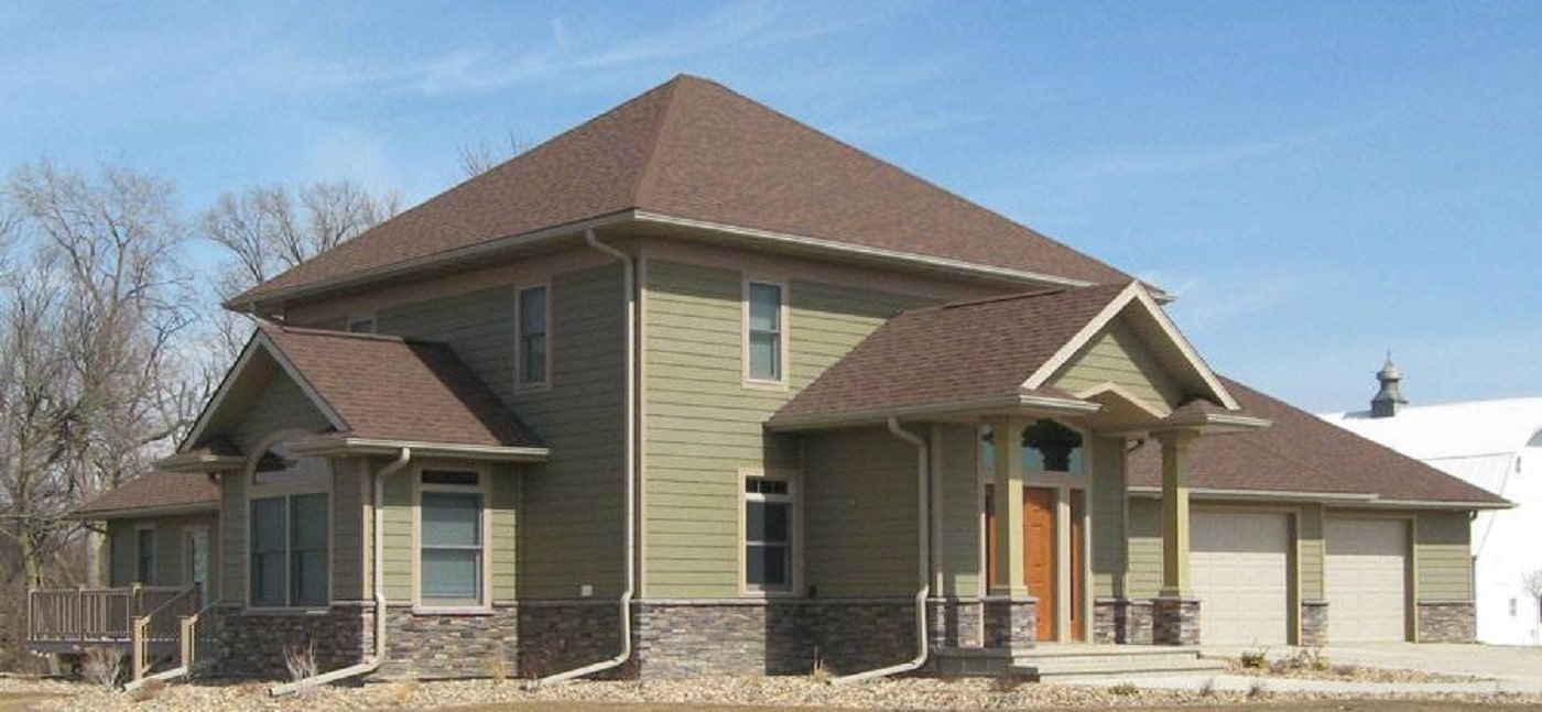 Twin Cities home with green siding and brown roof 