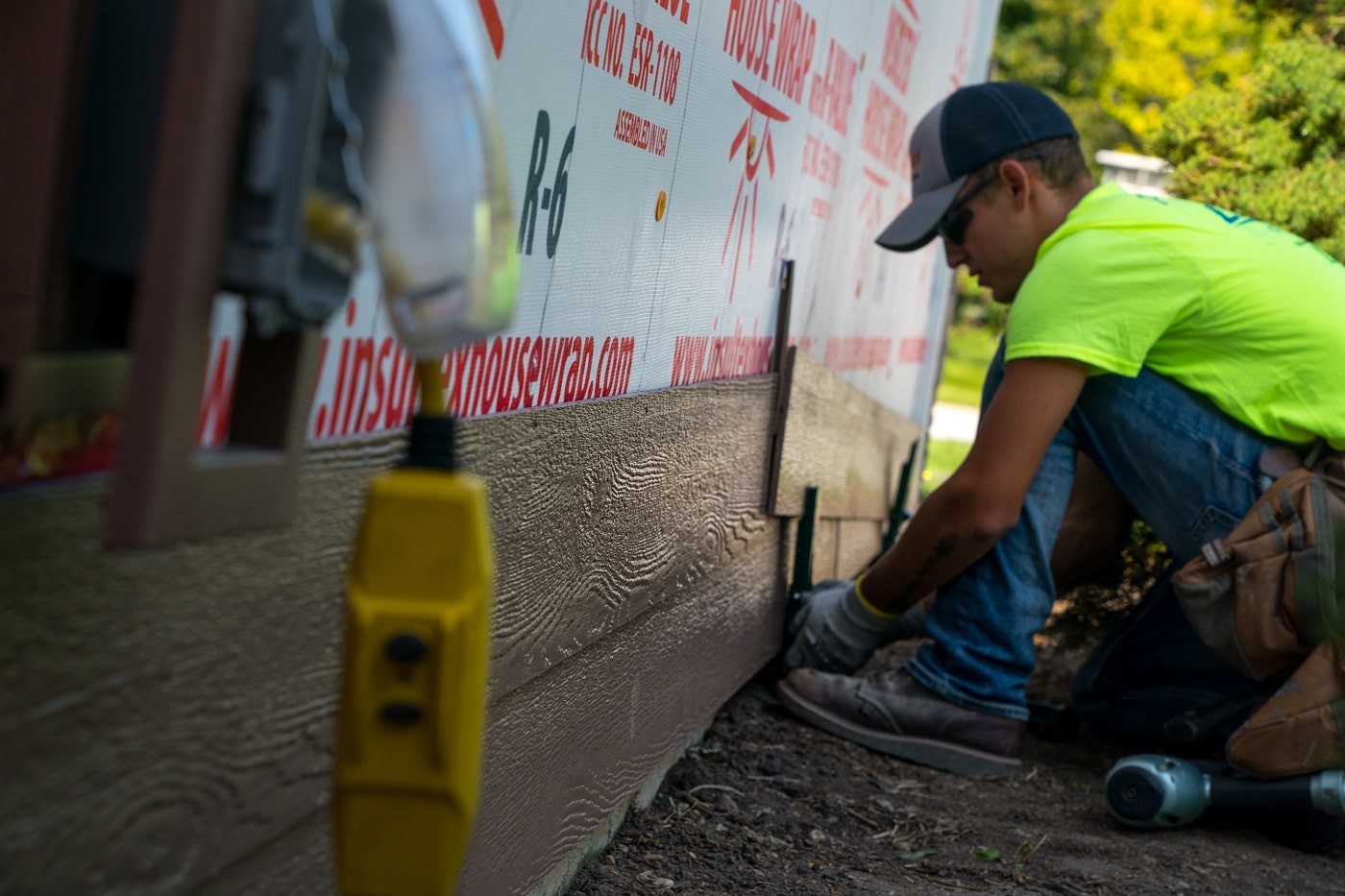  Lindus Construction worker installing siding using Gecko gauge clamps